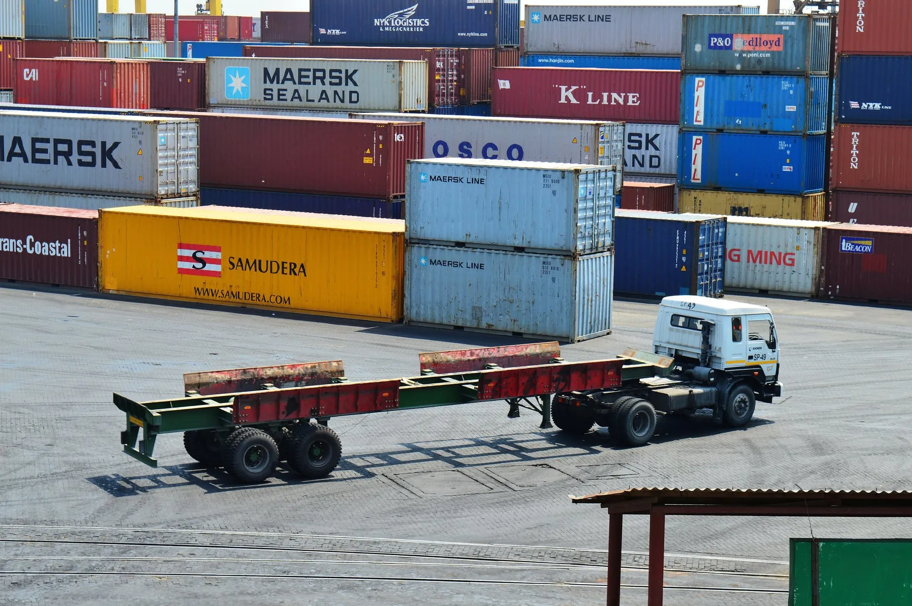 Patio de contenedores apilados en una terminal portuaria